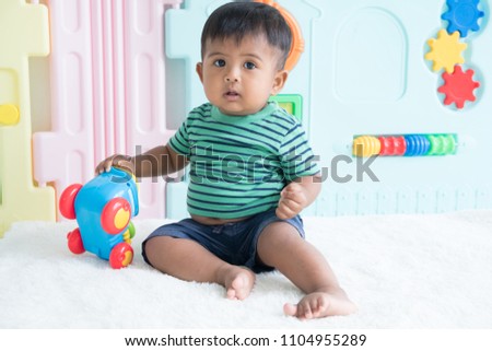 Cute little asian baby sitting play toy car