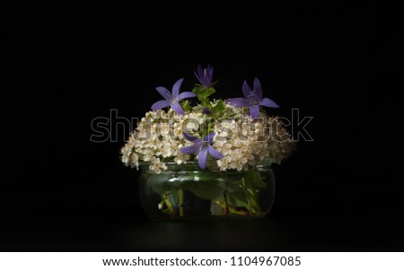 
flower bouquet in small vase on black background