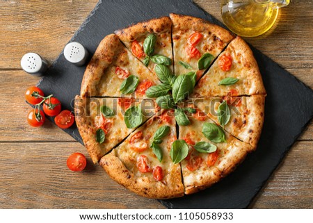 Composition with delicious pizza Margherita on wooden background