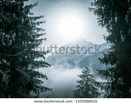 Mountain peak in a foggy scenery winter landscape Royalty-Free Stock Photo #1105088426