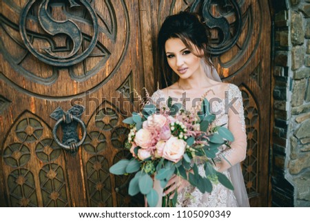 Happy Bride pose with bouquet near the door