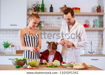 Image of parents with daughter cooking food in kitchen