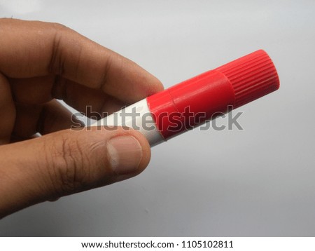 Hand of man holding a red color whiteboard marker