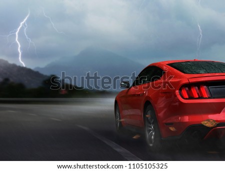 Red sport car drive on mountain highway in storm night Royalty-Free Stock Photo #1105105325