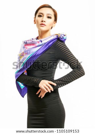 Young beautiful Chinese girl wearing a purple silk scarf over white background