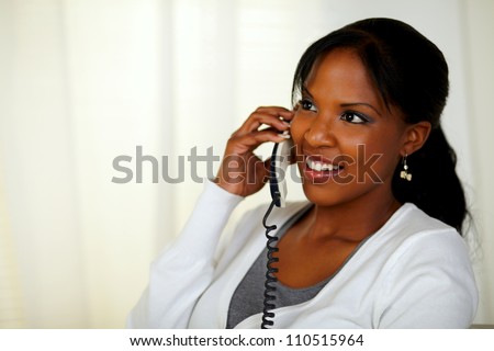 Portrait of a charming relaxed woman speaking on phone at home indoor