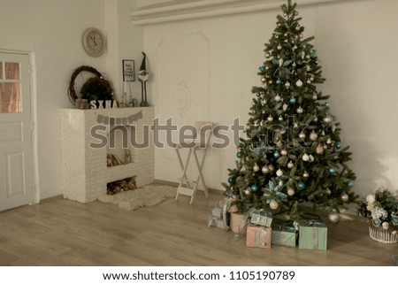 white room with white fireplace. white stone fireplace in the bedroom. new year's interior . Christmas tree by the fireplace