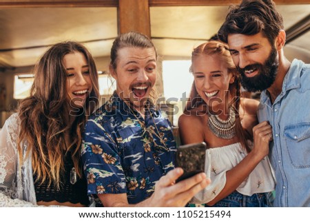 Smiling young people taking selfie with cellphone. Laughing young men and woman taking selfie picture with smart phone.