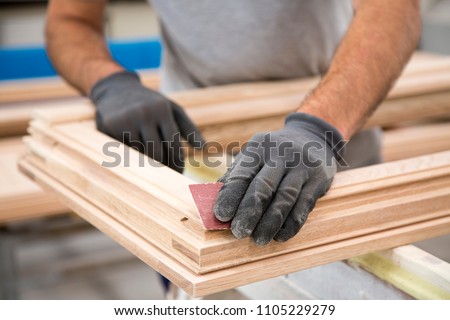 Man who is sanding a window frame Royalty-Free Stock Photo #1105229279