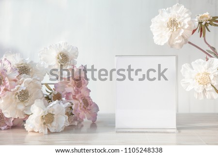 Mock up Menu banner standing on the table with Florist flowers.label acrylic tent card Used for Menu Bar and restaurant can be used for display or montage anything your products or picture frame
