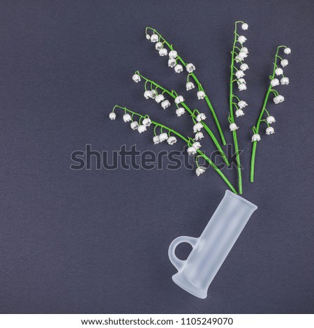 Artistic Beautiful bouquet of lilies of the valley on a dark black paper background. Square Top view with copy space in minimal style, template for text