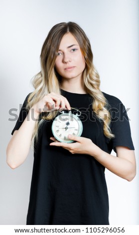 beautiful blond girl holding a retro alarm clock, isolated studio photo on a background