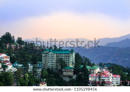 Buildings of shimla shot against the blue and pink dusk sky in Shimla. The hills and mountains fading off into the distance shows the beauty of the place