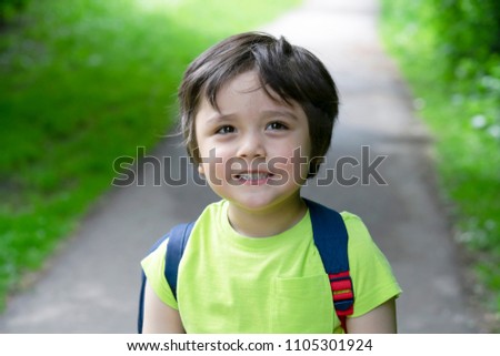 Portrait of 4 years old boy looking at camera with beautiful brown eyes and smiling face, Excited kid carrying backpack get ready to go to for adventure with school summer camp