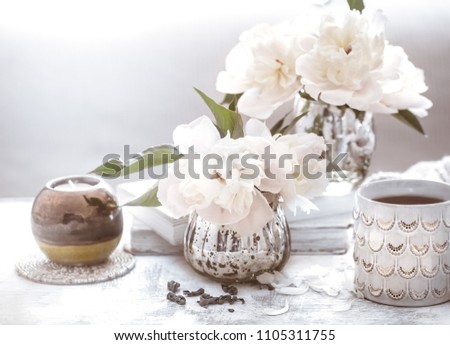 still life with interior details and flowers with peonies in the living room, the concept of home comfort and interior