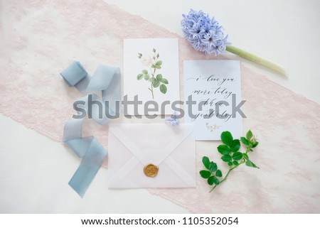 wedding invitation card as a decorated letter with flowers and ribbons top view