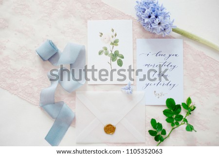 wedding invitation card as a decorated letter with flowers and ribbons top view