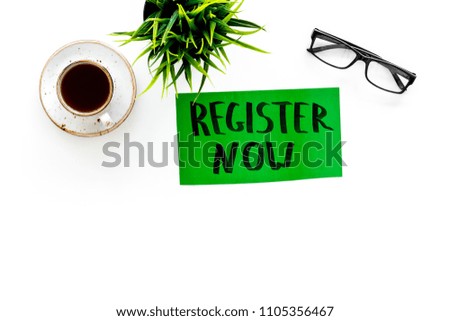 Membership concept. Template for registration. Register now hand lettering iconon word desk with glasses, coffee, plant on white background top view space for text