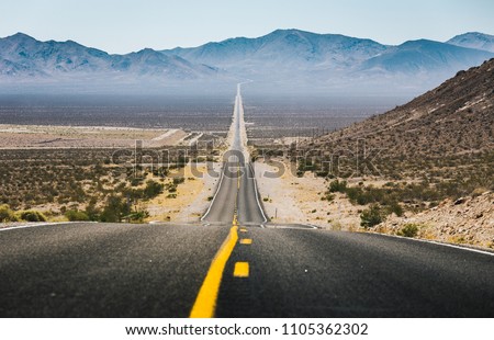 Classic panorama view of an empty long highway road in the American West on a beautiful sunny day in summer, USA, North America Royalty-Free Stock Photo #1105362302