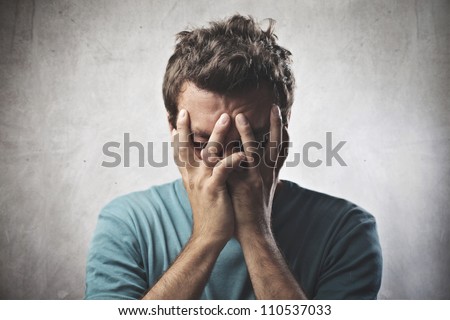 Desperate young man crying in his hands Royalty-Free Stock Photo #110537033