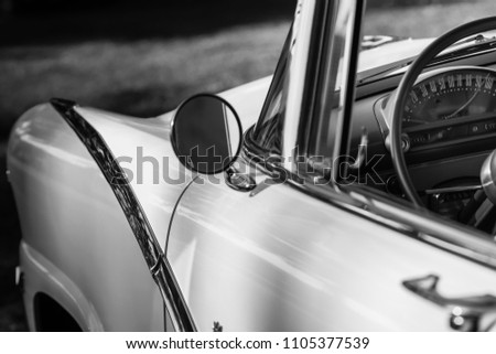 Monochrome picture of vintage car dashboard seen from outside the car through the window