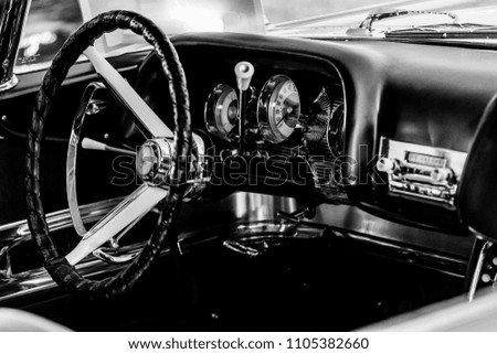 Monochrome picture of vintage car showing close up view of car dashboard