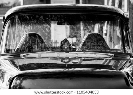 Monochrome picture of vintage car showing hood and windshield