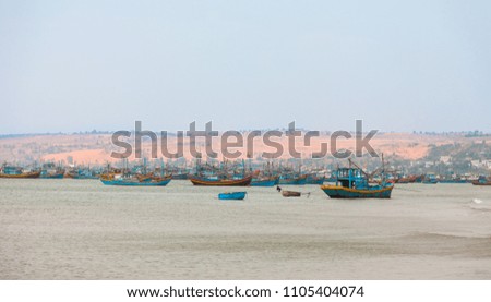 Vietnamese fishing boats on the water in background of Red Sand Dunes at the bay of Mui Ne fishing town in south Vietnam.