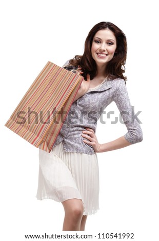 Happy woman keeps striped paper gift bag, isolated on white
