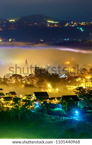 Aerial view of Chicken cathedral and Da Lat city, Vietnam. Fog on top of city in the night. View from Du Sinh mountain