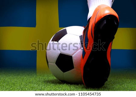Close up legs and feet of soccer player or football player walk on green grass ready to play match on national Sweden flag background.