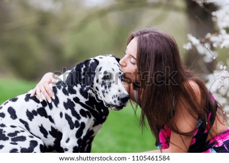 picture of a young woman who gives her Dalmatian dog a kiss