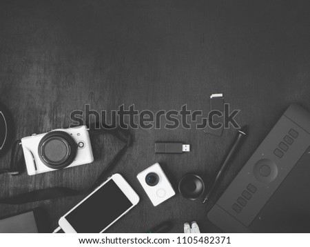 top view of graphic design concept with digital camera, memory card, smartphone and graphic tablet on black table background with copy space, Creative Designer concept