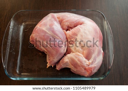 Raw rabbit carcass on wooden table