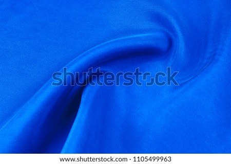 Background texture, pattern. Thick thick silk fabric of blue color. Add a touch of luxury to any design, building it with this super-heavy and very dense polyester fabric.