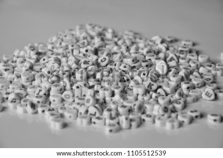 Black and white picture of many heart-shaped beads and letters on the top.