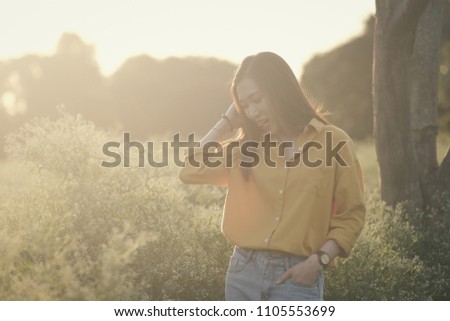 The girl in the wild flower garden at sunset in April every year in Hanoi, Vietnam.