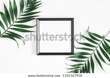 Tropical palm leaves, photo frame, on white background. Summer concept. Flat lay, top view, copy space