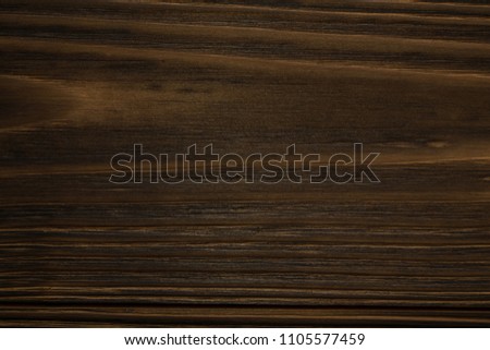 Old dark burnt wood background. Scorched wooden board plank texture. Natural rustic photo backdrop for vintage hipster design