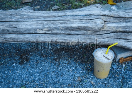 Iced coffee is placed with a log.