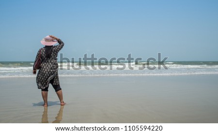 A young lady dressed in Indian costumes relaxing and enjoying the view of sea.