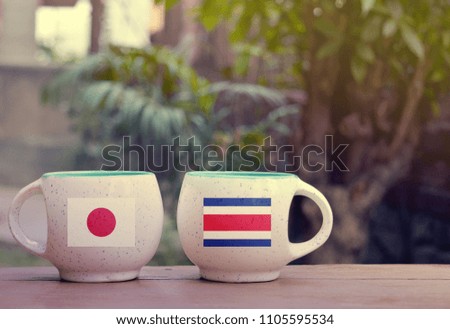 Japan and Costa Rica Flag on two tea cups with blurry background