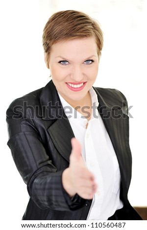 Young happy business woman at office gives a handshake