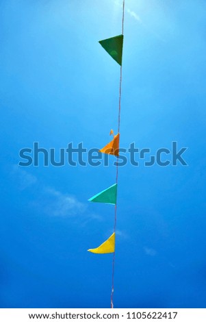 Multicolored triangular paper festival flags on blue sky background. Outdoor Celebration Party. Festive mood