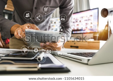 businessman hand working with laptop computer, tablet and smart phone in modern office with virtual icon diagram at modernoffice in morning light 
