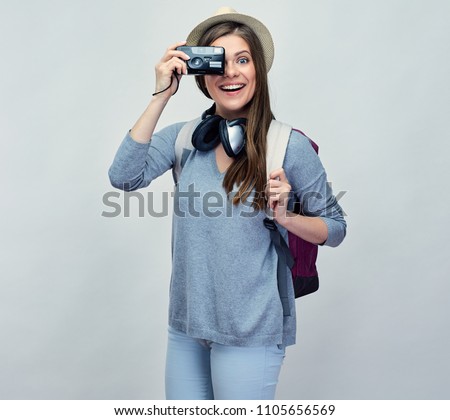 Woman traveler taking pictures with camera. Isolated portrait.