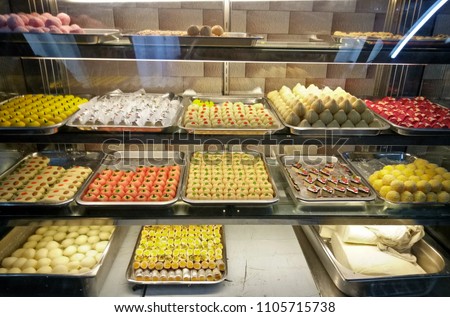 Indian desserts shop. Indian desserts colorful in the glass cabinet for sale at Phahurat market, Bangkok Thailand. Royalty-Free Stock Photo #1105715738