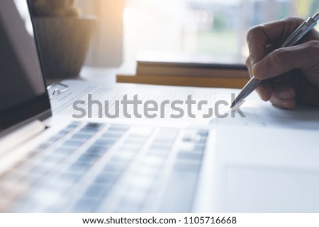 Businessman signing official contract with laptop computer on office desk. business agreement, deal concept. close up