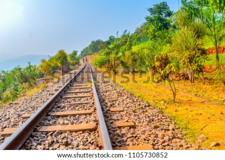 Railways Metal Track on green mountain background against clear blue sky. Vizag India 