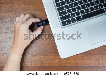 business man inserting USB 3.0 thumb  drive to laptop computer